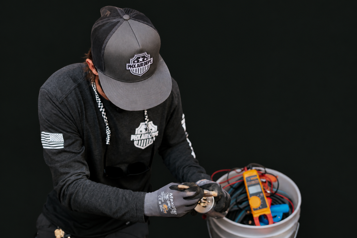 Technician testing an outdoor AC unit with diagnostic instruments
