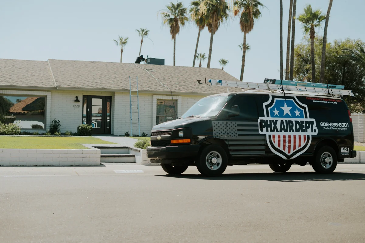 Branded Phoenix Air Department van on a palm-lined residential street